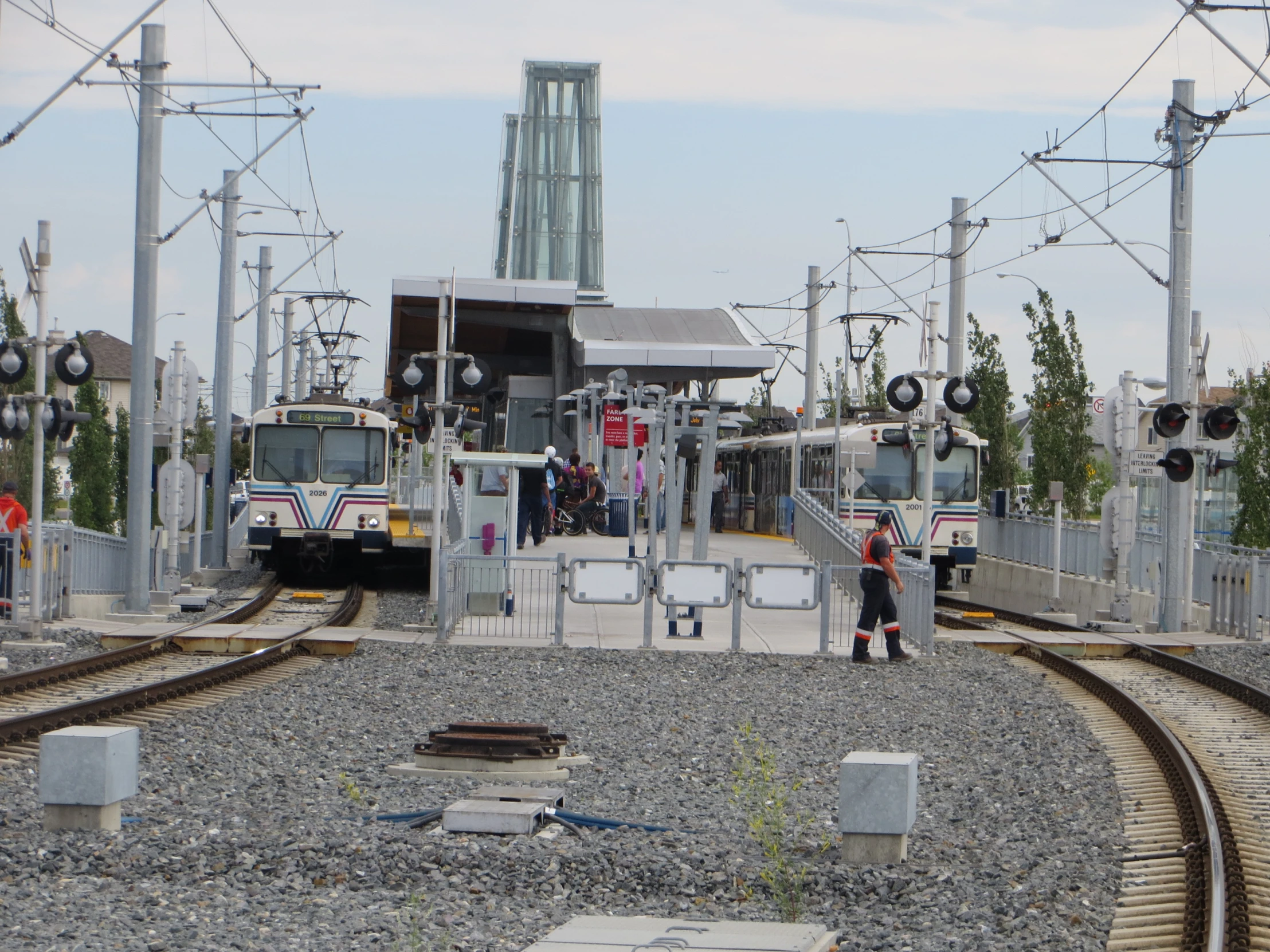 people waiting for trains on the rails at a train station