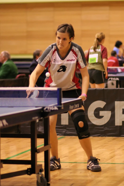 a girl on a table tennis table ready to strike the ball