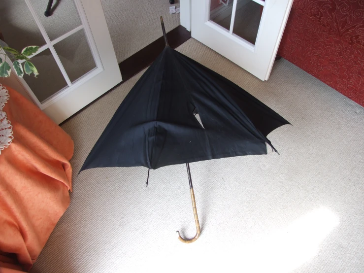 a black umbrella laying upside down in a room