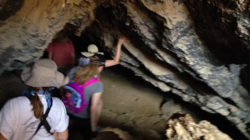 some people in a cave walking to get out of it