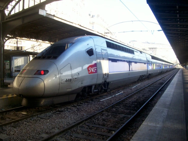 a silver train with a red on the side of it