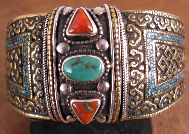 the ring is decorated with turquoise, orange and white stones