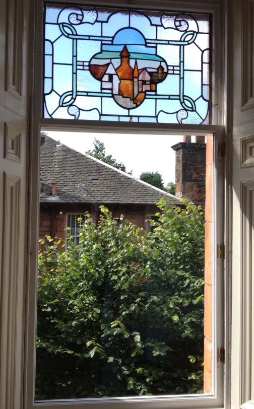 view from an open window of a garden through which trees grow