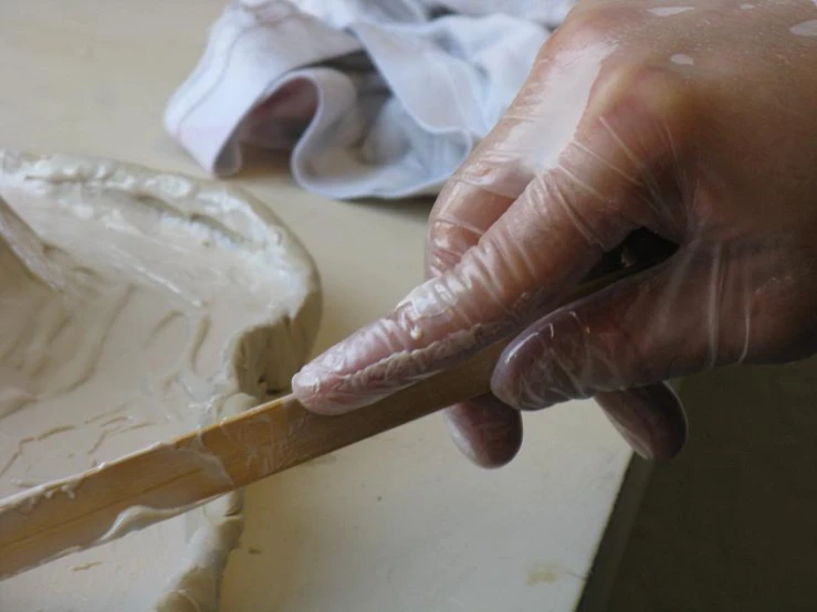 someone that is preparing a pan with a wooden handle