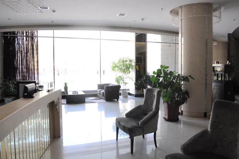 a living room with two grey chairs in front of glass walls