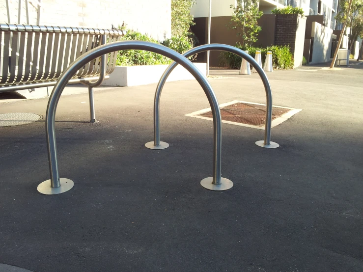 two metal bars on the ground next to a bench