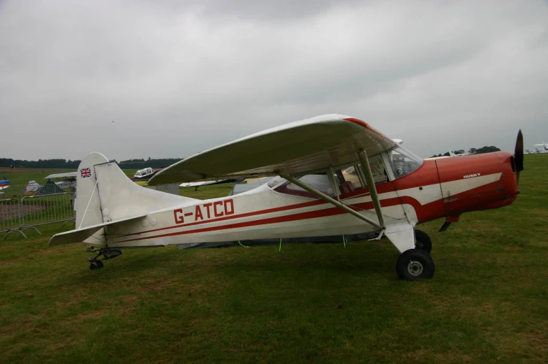 small propeller plane sitting on a field of grass