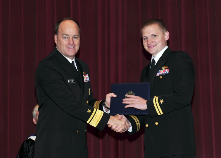 two men in military uniform are standing near each other