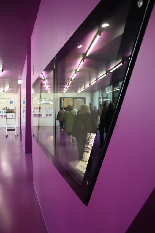 a purple building with people standing in the hallway