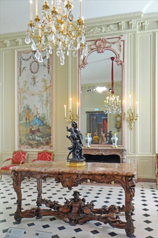 a fancy table is surrounded by chairs and mirrors