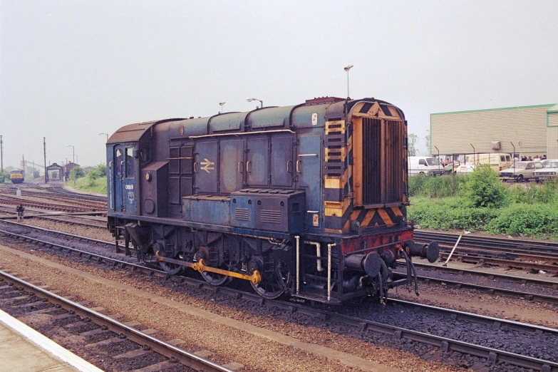 a train sits on some tracks near a field