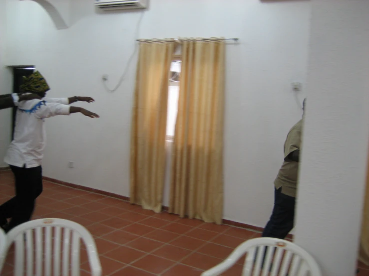 a couple of people standing in a room near a window