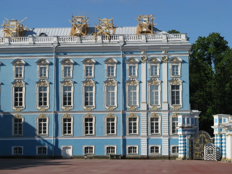 a very large blue building in front of some trees