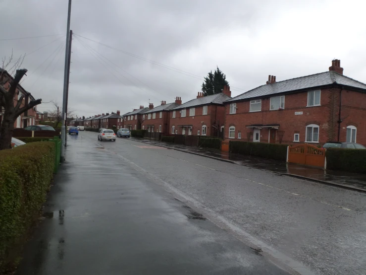 cars parked along the street on a rainy day