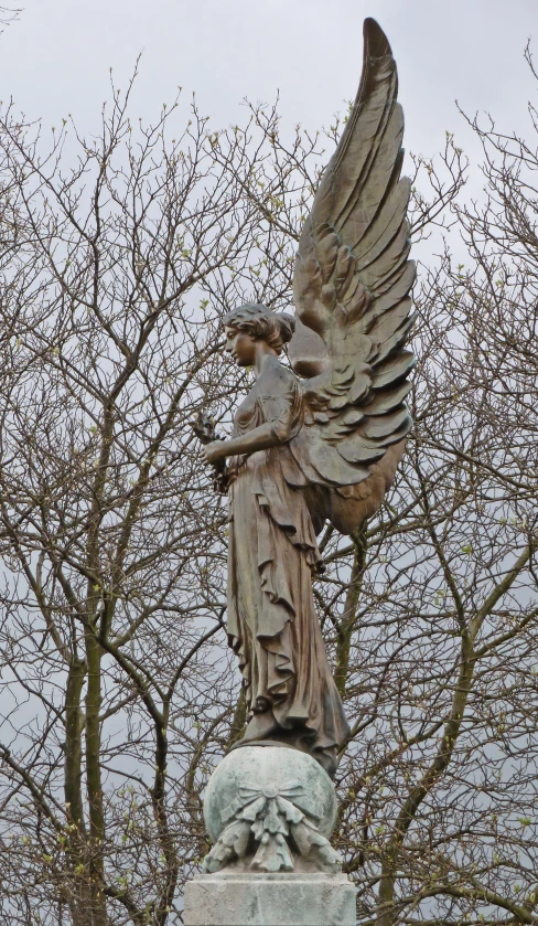 a statue with a halo and a winged angel on top