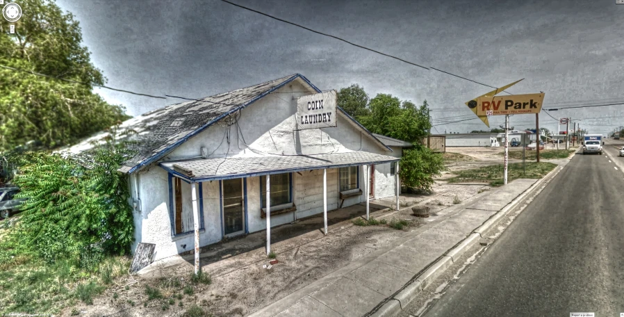 a house in the middle of the country with a sign in front