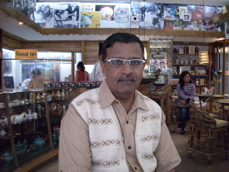 a man with glasses sitting at a store