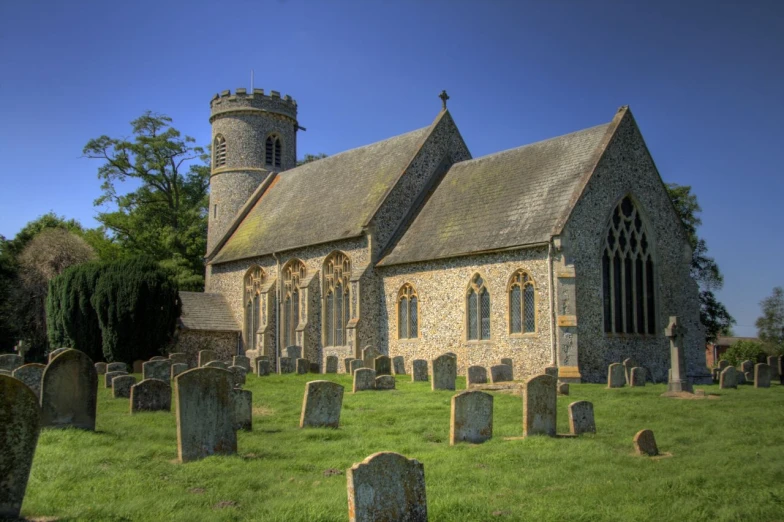 an old stone church with a tower is surrounded by tombstones