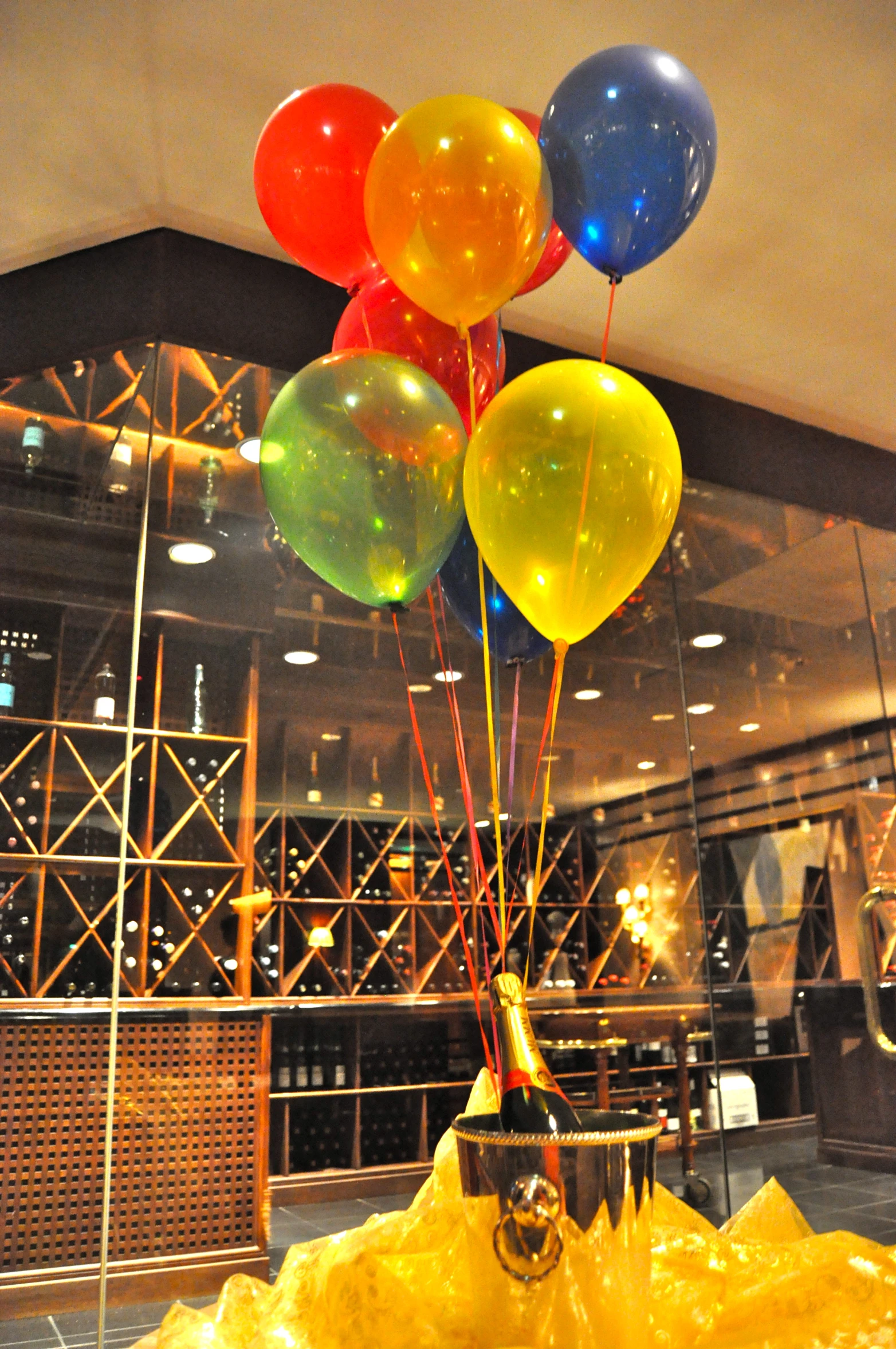 balloons being flown in a glass box on a yellow plastic structure