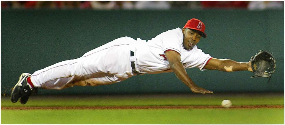 a baseball player dives to catch a ball