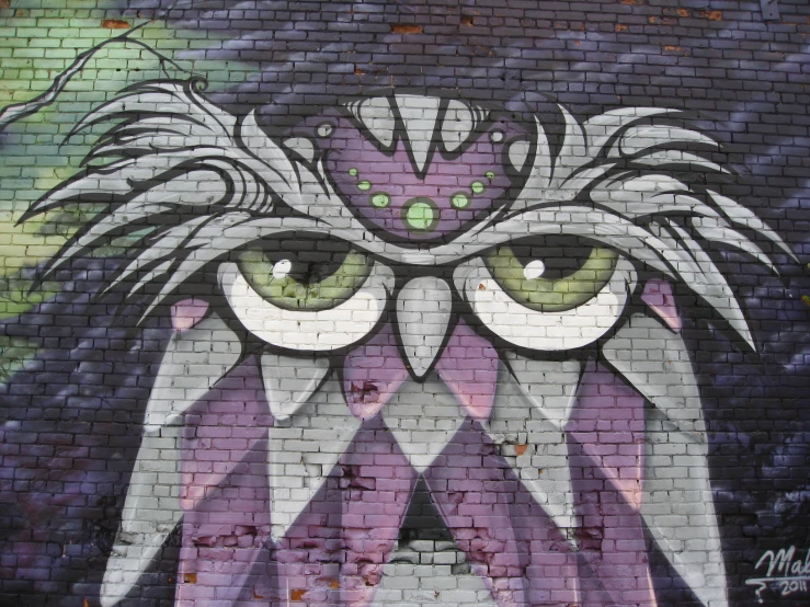 an owl painted on the wall with green eyes