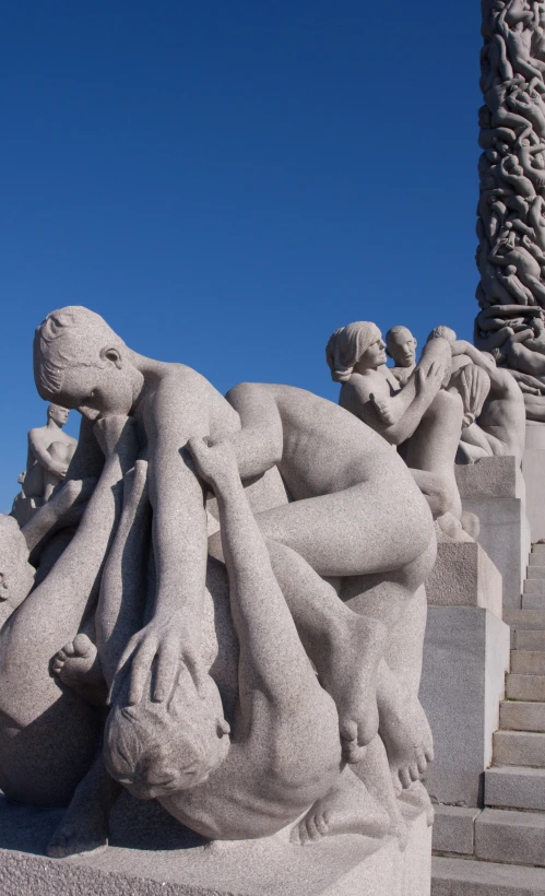 statues of women sitting near a pillar, one with her back to the camera