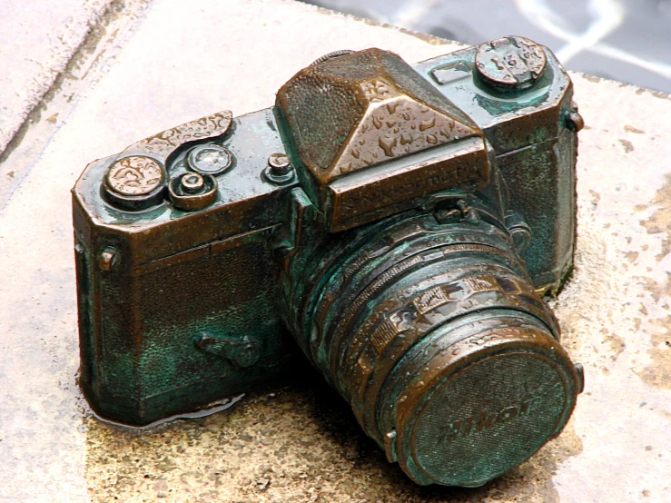 an old camera on the ground near some rocks