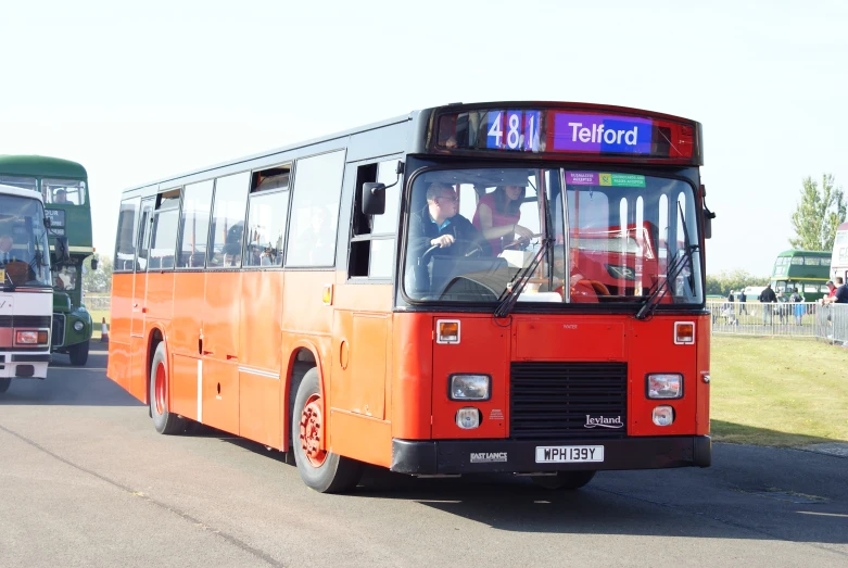 two buses driving down a street next to other vehicles