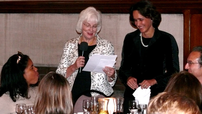 two women talking to each other at a banquet