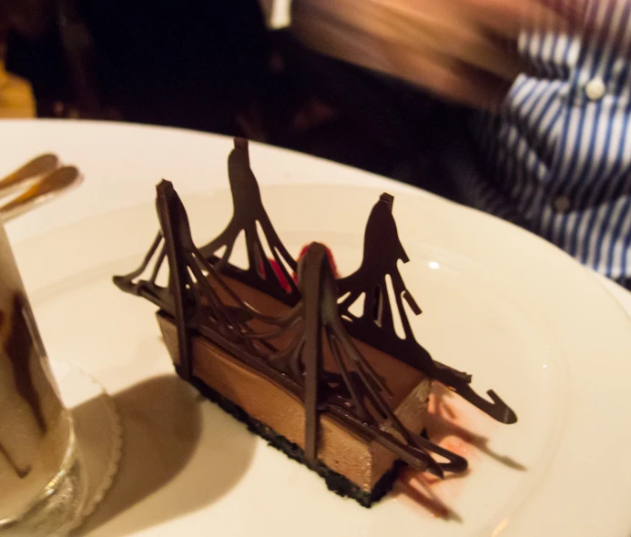 a piece of chocolate dessert on top of a plate with spoons