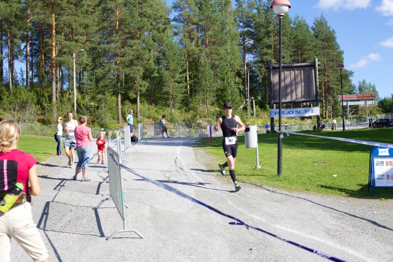 the people are running along side a path with tennis rackets