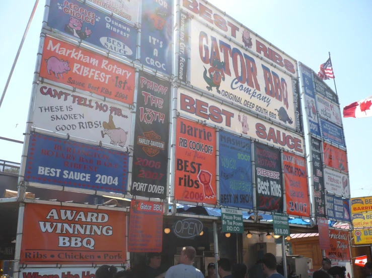 a group of people walking down a street by a tall building covered in signs