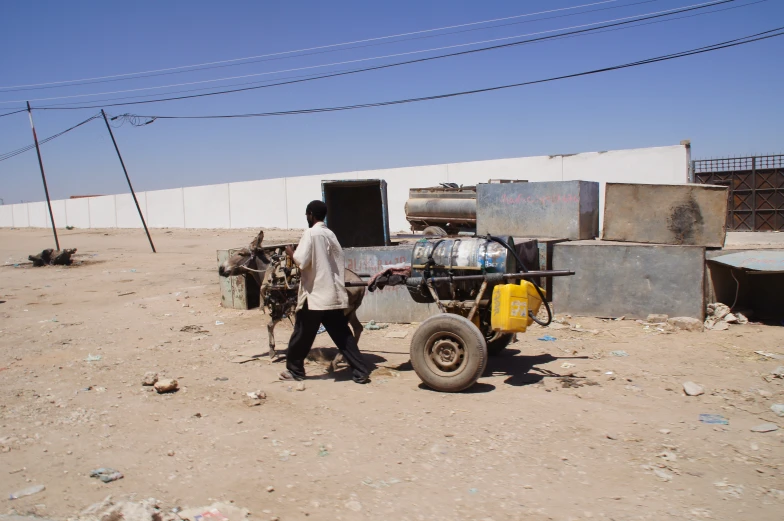 there is a man walking near a vehicle