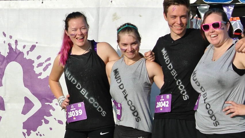 three women with pink hair are showing off their medal for a race