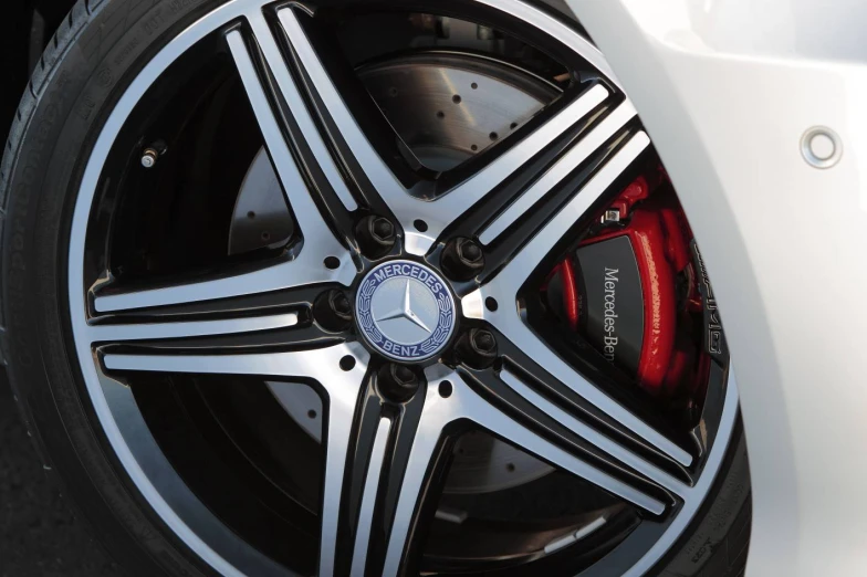 the wheel of a mercedes car parked in front of a building