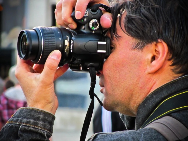 the man is holding up his camera to take a picture