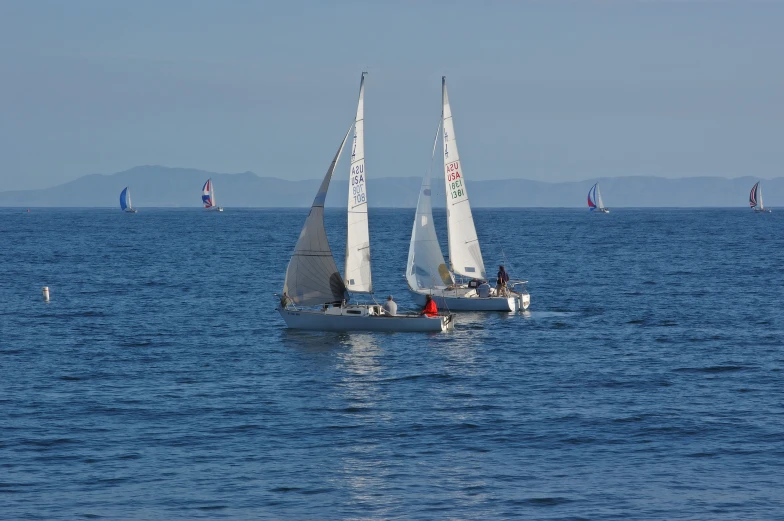 sailboats in open water in front of mountains