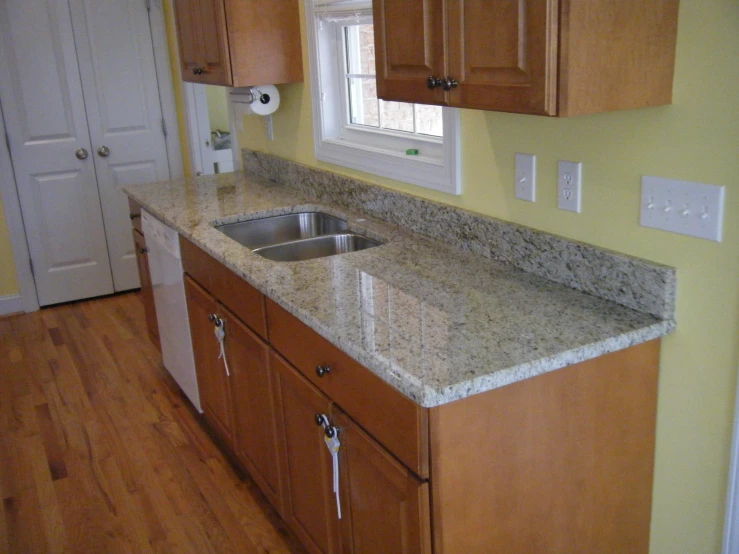 a kitchen with marble countertops and wooden cabinets