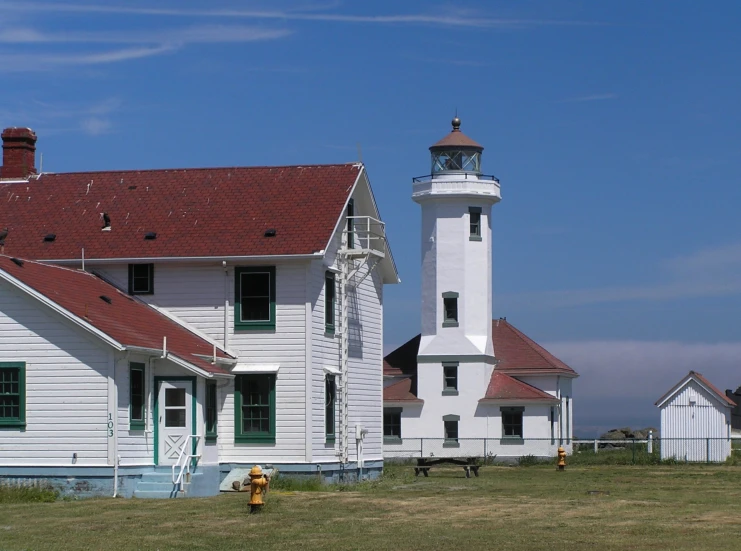 a white building with a red roof and a white lighthouse