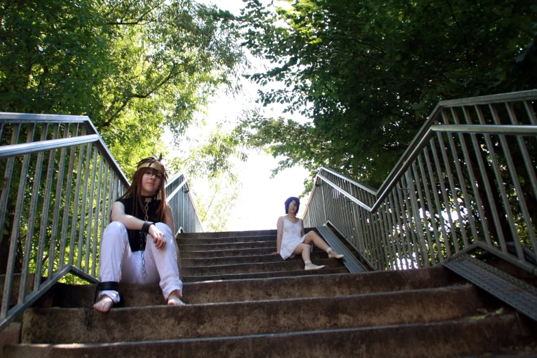 there are two girls sitting on stairs going up the stairs