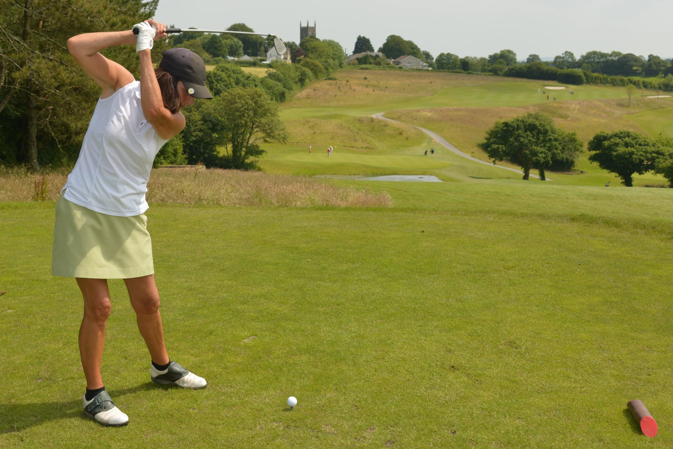 a man with a hat swinging his golf club