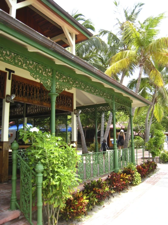 an outdoor covered cafe with palm trees and people