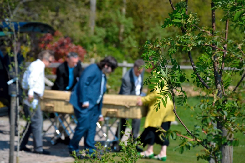 many people gathered around a table with wooden benches