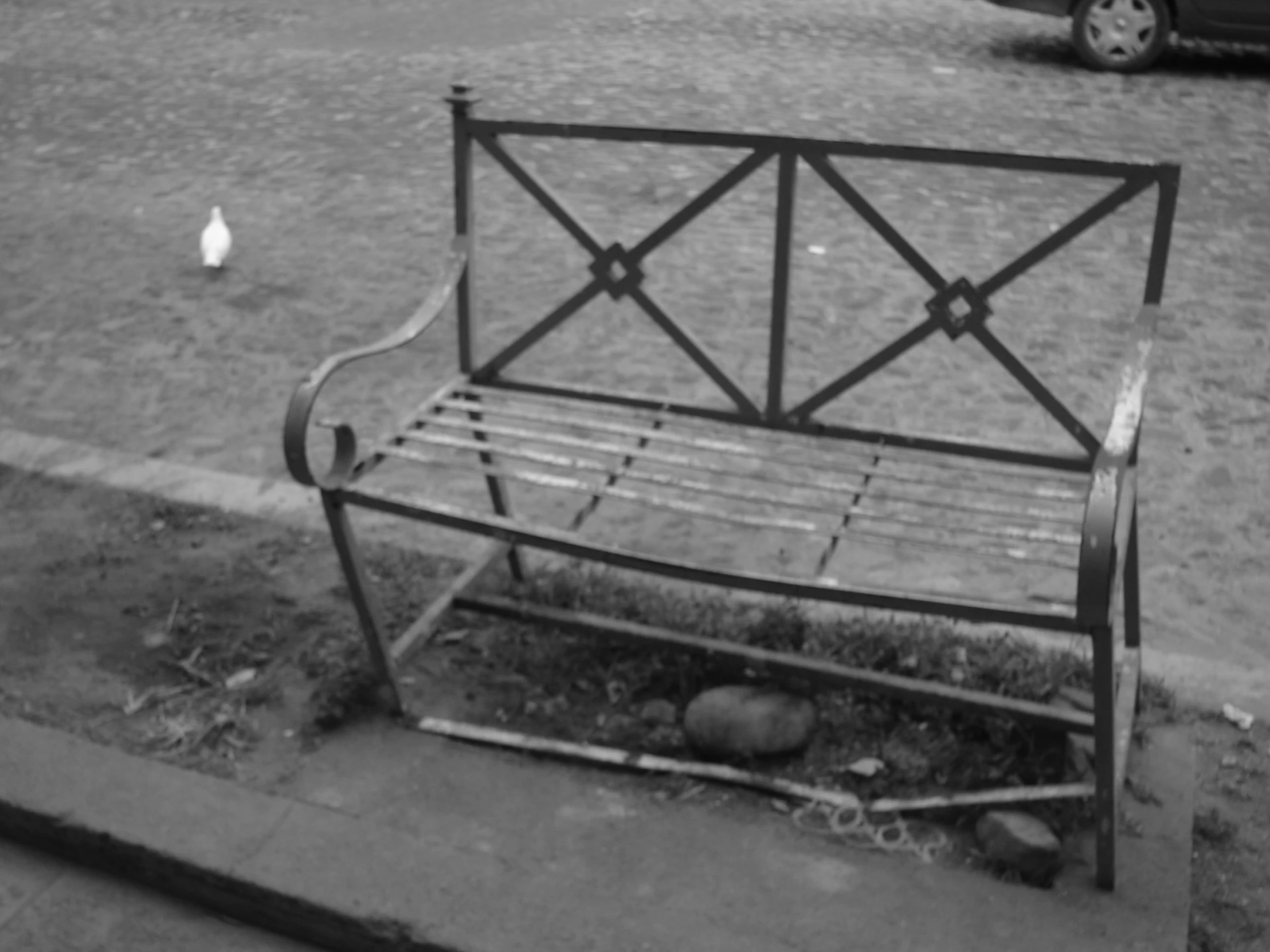 a broken bench in front of a parking lot