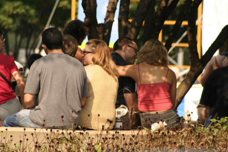 two men and a woman sitting in a park