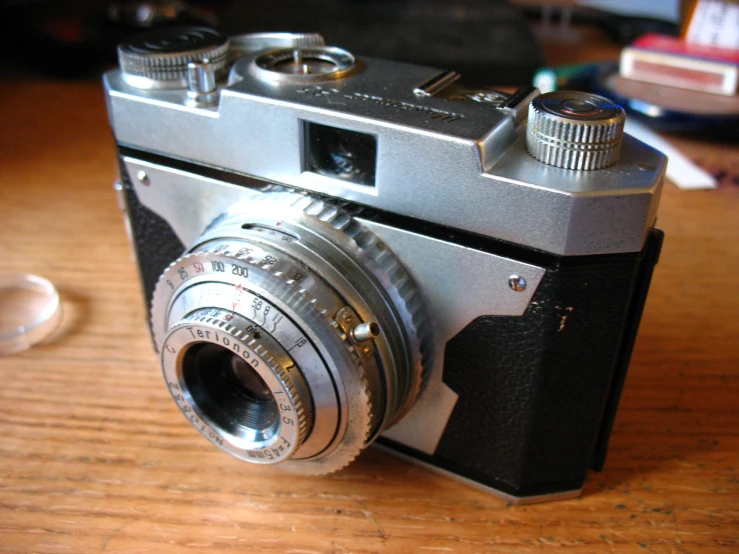 a old fashioned camera on top of a wooden table