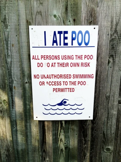 a sign for swimming is posted in a fence