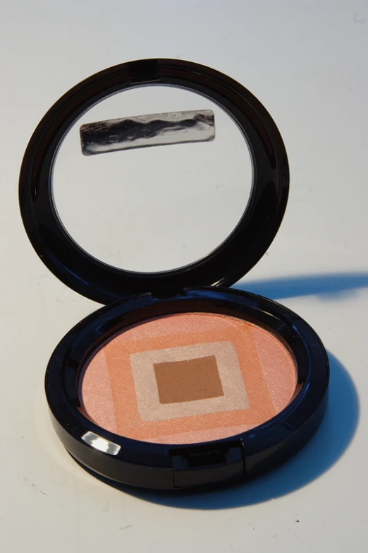 an compact powder compact make - up with a flat, circular top