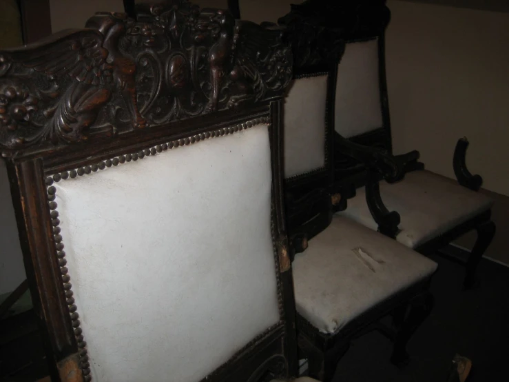 a dining room set with a fancy mirror and upholstered chairs