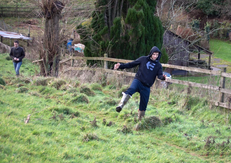 two people in a fenced pasture playing frisbee